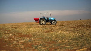 A farm workers spreads fertilizer