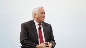 Walter Isaacson speaking in red tie, in front of light grey background