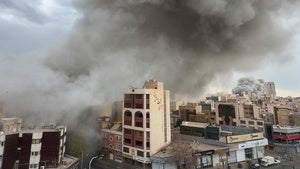 Plumes of smoke from two simultaneous strikes rise over Tehran, Iran