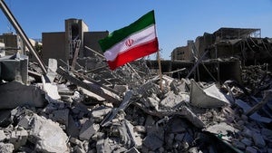 An Iranian flag is placed among the ruins of a police station