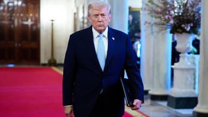 Donald Trump walks down a hallway in the White House