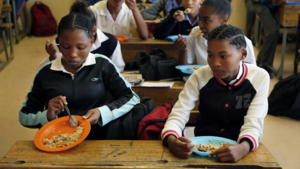 Children share a meal they received from a government sponsored feeding scheme at the Delta Primary School in Vosburg, South Africa.