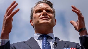 Secretary of Defense Pete Hegseth raises his hands