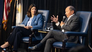 Two people speaking on a stage.