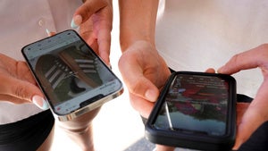 teens hold their cell phones
