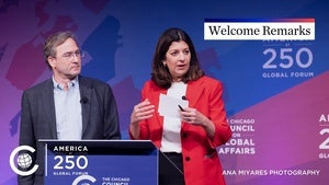 Two people stand on stage behind a podium