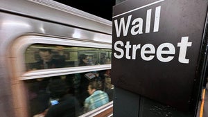 A sign reading "Wall Street" hangs in the New York subway.