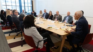 Group of people sitting around a table during a brieifing 