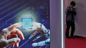 A man browses his phone near an artificial Intelligence booth at the China International Supply Chain Expo in Beijing on June 25, 2026.