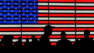 Silhouettes against a backdrop of the American flag