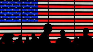 Silhouettes against a backdrop of the American flag
