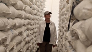 Cindy McCain walks by bags of food aid