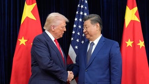  President Donald Trump, left, and Chinese President Xi Jinping, right, shake hands before their meeting at Gimhae International Airport
