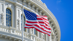 An American flag in front of the US Capitol building