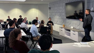 People sit around tables in a conference room