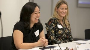 A woman speaks into a microphone during a meeting