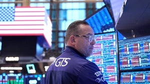 A person stands in front of multiple computer screens
