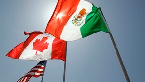 A Canadian flag and a Mexican flag fly in front of an American flag