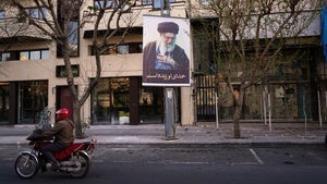 A motorcycle drives past a picture of the late Iranian Supreme Leader Ayatollah Ali Khamenei along an empty street in Tehran, Iran, Sunday, March 1, 2026, following the confirmed death of Khamenei in U.S. and Israeli strikes. 