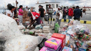 Activists from the vessel Maguro that arrived from Mexico, behind, as part of the "Nuestra America," or Our America convoy, unload humanitarian aid with the help of Cuban port workers in Havana Bay, Cuba, Tuesday, March 24, 2026. 