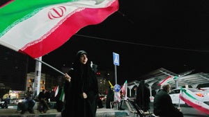 A woman waves an Iranian flag during a pro-government gathering at a square in Tehran, Iran, Tuesday, Aug. 11, 2026. 