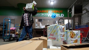 A customer carries grocery products at Market Depot Wholesale Wednesday, March 25, 2026, in Dearborn, Mich. 